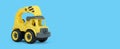 Yellow plastic truck toy isolated on blue background. construction vechicle truck.