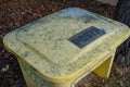 Yellow Plastic Winter Grit Sand Box Covered in Snow Standing by Icy Pavement Royalty Free Stock Photo