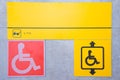 Yellow plate with the image of a disabled person and a call button