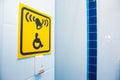 Yellow plate with the image of a disabled person and a call button