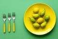 a yellow plate with pears and forks on a green background Royalty Free Stock Photo