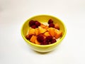 Yellow plate with porridge and fruits. Apricot and cherry.