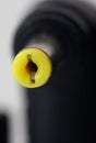 A yellow plug with a black plug on the end Royalty Free Stock Photo