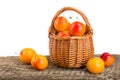 Yellow plums with leaf in a wicker basket on wooden table with white background Royalty Free Stock Photo
