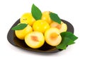 Yellow plums with leaves on a black plate Royalty Free Stock Photo
