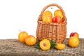 Yellow plums in a wicker basket on wooden table with white background Royalty Free Stock Photo