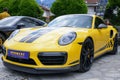 The yellow porsche 911 gt4 parked in a parking lot