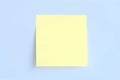 Single yellow post it on blue background