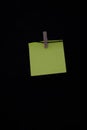 Yellow post it with wooden clothespin with dark background copy space vertical annotation