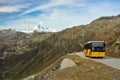 Yellow postbus on high mountain pass