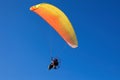 Yellow Powered Parachute, operated by pilot flies flies in the blue sky Royalty Free Stock Photo