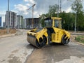 Yellow powerful large new modern road roller for asphalt paving and road repair at construction site. Construction machinery Royalty Free Stock Photo