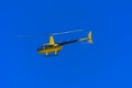 Yellow private helicopter in flight against the background of a Royalty Free Stock Photo