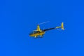 Yellow private helicopter in flight against the background of a Royalty Free Stock Photo