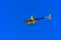 Yellow private helicopter in flight against the background of a Royalty Free Stock Photo