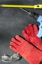 Yellow professional measuring tape, electric drill, protective gloves and glasses on the black background.Empty space for text.Con Royalty Free Stock Photo