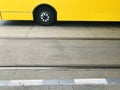 Yellow public bus with one wheel standing in a bus stand in Berlin