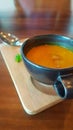 Yellow pumpkin soup in black soup cups