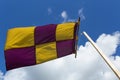 Yellow and purple flag on a banner swaying against the wind on a Royalty Free Stock Photo