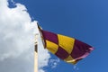 Yellow and purple flag on a banner swaying against the wind on a Royalty Free Stock Photo