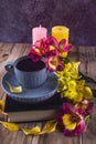 Yellow and purple flowers of alstroemeria, blue cup of coffee. Romantic composition with candles and a book Royalty Free Stock Photo