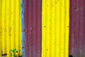 Yellow and purple metallic fence closeup, colorful material photo texture. Corrugated iron rustic surface closeup