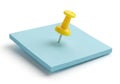 Yellow pushpin piercing a light blue sticky note isolated on white background Royalty Free Stock Photo