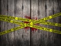 Yellow quarantine zone tape for warning over quarantine area on outbreak situation with bloody dirt wooden wall background