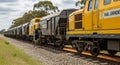 Yellow rail grinding train actively working on tracks, creating sparks, with a long train of wagons behind it Royalty Free Stock Photo