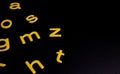 Yellow random letters on black background Royalty Free Stock Photo