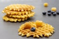 Yellow raspberries and blueberries on waffle. Berries and waffles on table