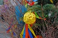 Yellow rattan ball hanging on a Christmas tree with ribbons on background of christmas garland