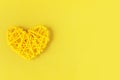 Yellow rattan wicker heart on a yellow background.Symbol of love.Valentine`s Day Royalty Free Stock Photo
