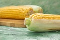 Yellow raw corn cobs on wooden board on table. Watercolor green background. food, vegetarianism Royalty Free Stock Photo