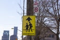 School children crossing traffic sign on a utility pole