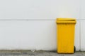 A yellow recycling container is on the street