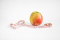 Yellow-red apple lies on a table with a measuring tape on a white Royalty Free Stock Photo