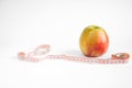 Yellow-red apple lies on a table with a measuring tape on a white Royalty Free Stock Photo