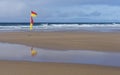 Yellow and red beach safety flag on a Cornish beach in black and white Royalty Free Stock Photo
