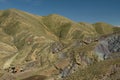 Streaked green and rainbow mountains in Maragua Crater. Bolivia with farm houses