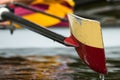 Yellow And Red Boat Oar Coming Out Of The Water With Drips