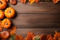 Yellow and red dried leaves and small orange pumpkins on brown wooden background, top view, copy space. Halloween, Thanksgiving