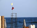 Yellow and red flags on the beach, beach warning flag system, red flag means High risk, rough conditions, strong surf, and