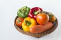 Yellow, red, green bell peppers, tomatoes, carrots in a basket Royalty Free Stock Photo