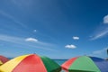 Yellow, red, green and blue beach umbrella on the shore with blue sky Royalty Free Stock Photo