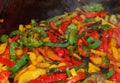 Yellow red and green peppers sizzling on the hot griddle Royalty Free Stock Photo