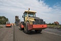 Yellow Red Heavy Vibration roller compactor at asphalt pavement works for road repairing. Working on the new road Royalty Free Stock Photo