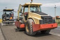 Yellow Red Heavy Vibration roller compactor at asphalt pavement works for road repairing. Working on the new road Royalty Free Stock Photo