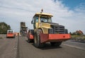 Yellow Red Heavy Vibration roller compactor at asphalt pavement works for road repairing. Working on the new road