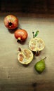 Yellow-red pomegranats and green pear on a wooden table